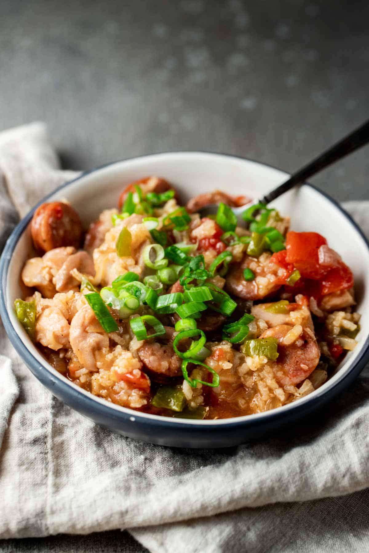 a bowl of rice with veggies and meats and garnished with green onions