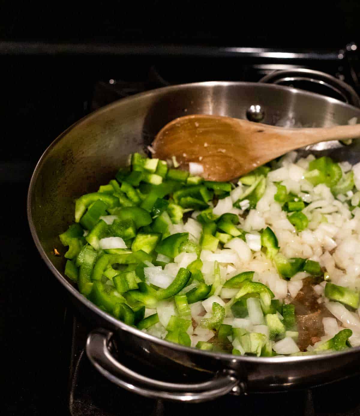 onions and green peppers being sauteed in a skillet
