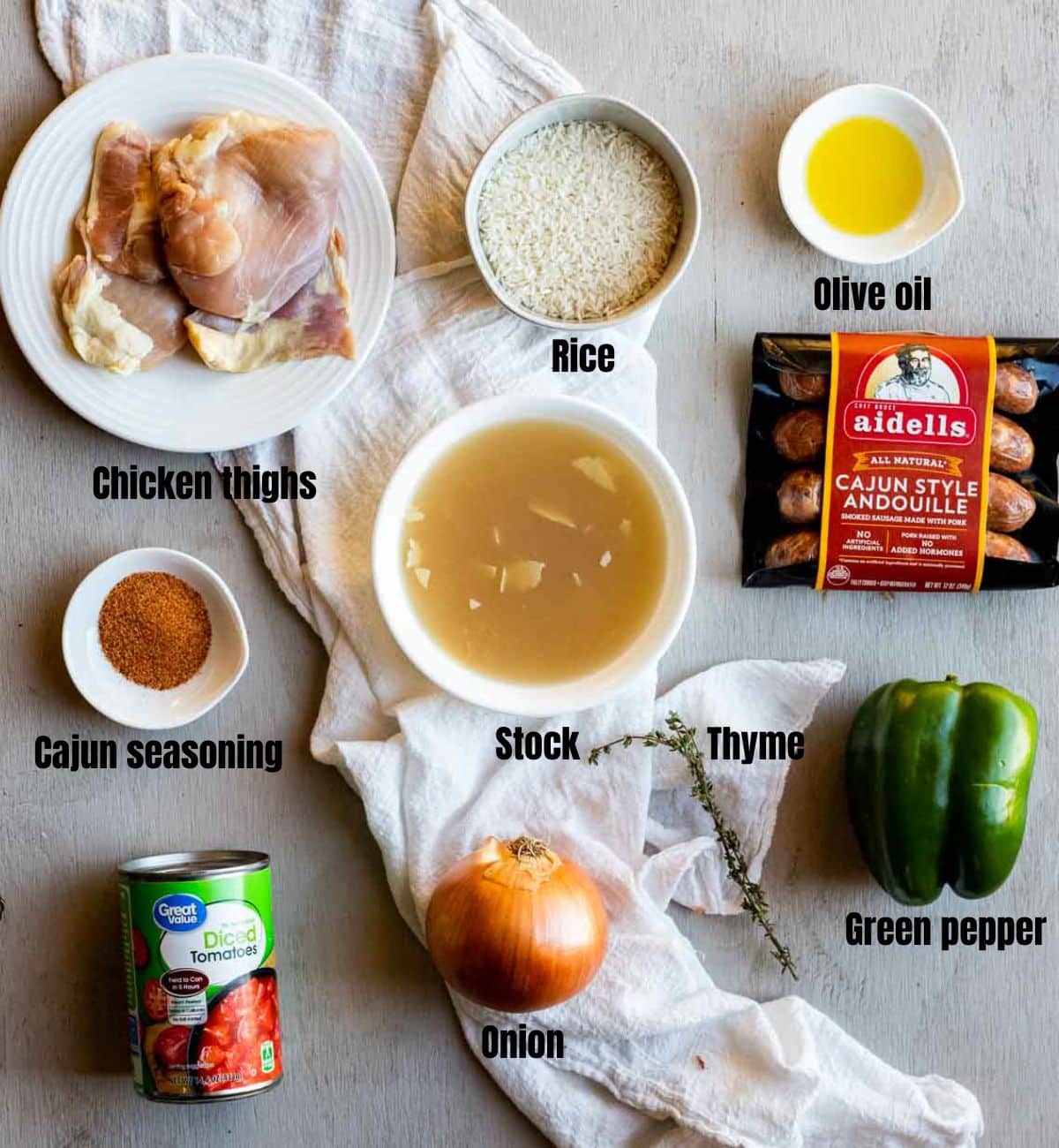 ingredients for chicken jambalaya on a gray board with labels