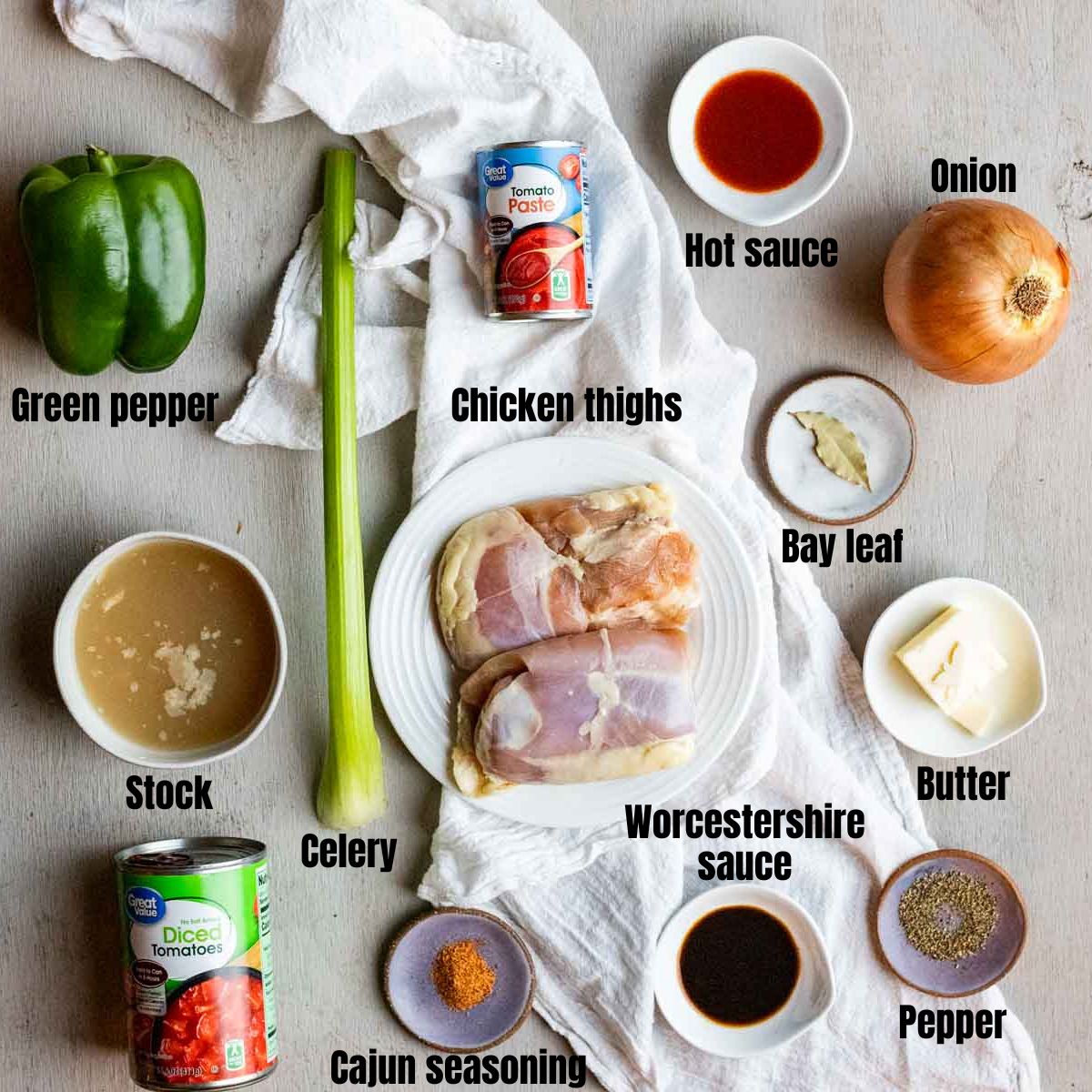 ingredients for creole chicken on a grey board