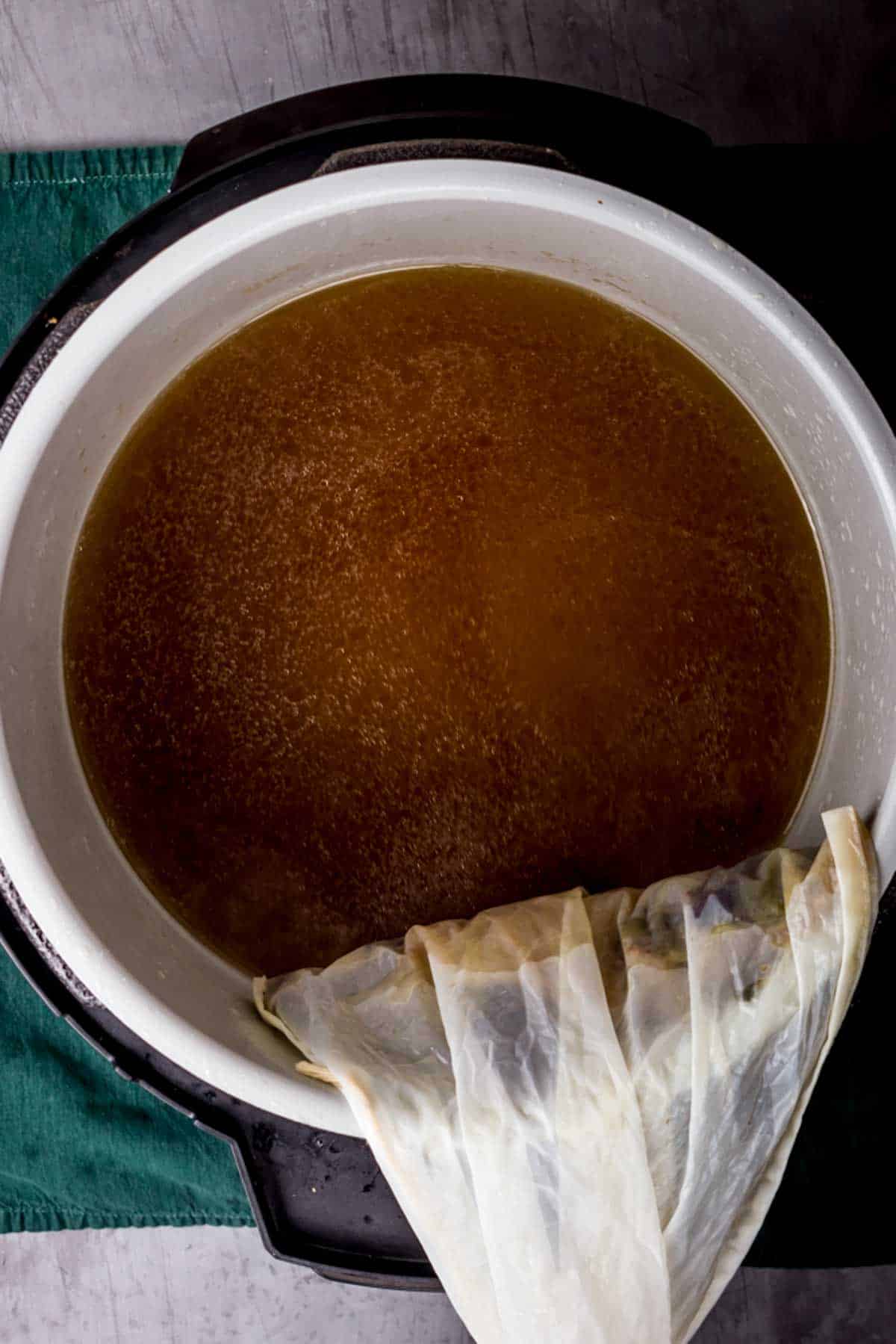 brown liquid in a pot being strained
