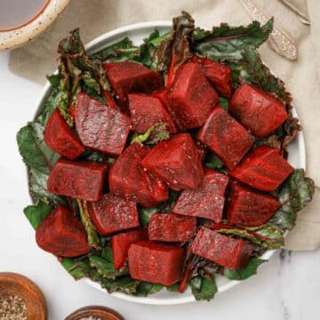 a plate of cooked beets over greens