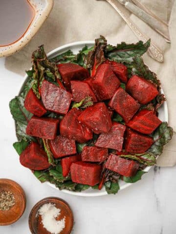 a plate of cooked beets over greens