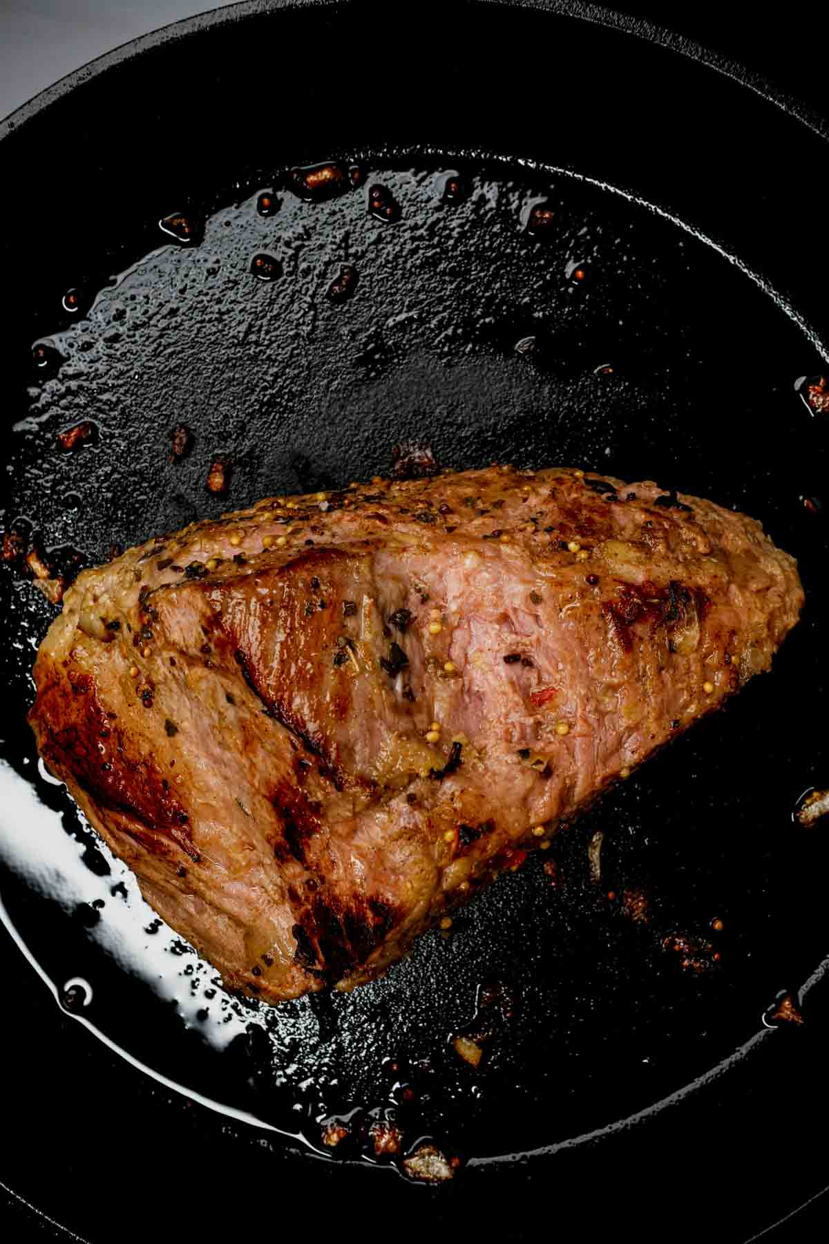corned beef brisket being seared in a pan