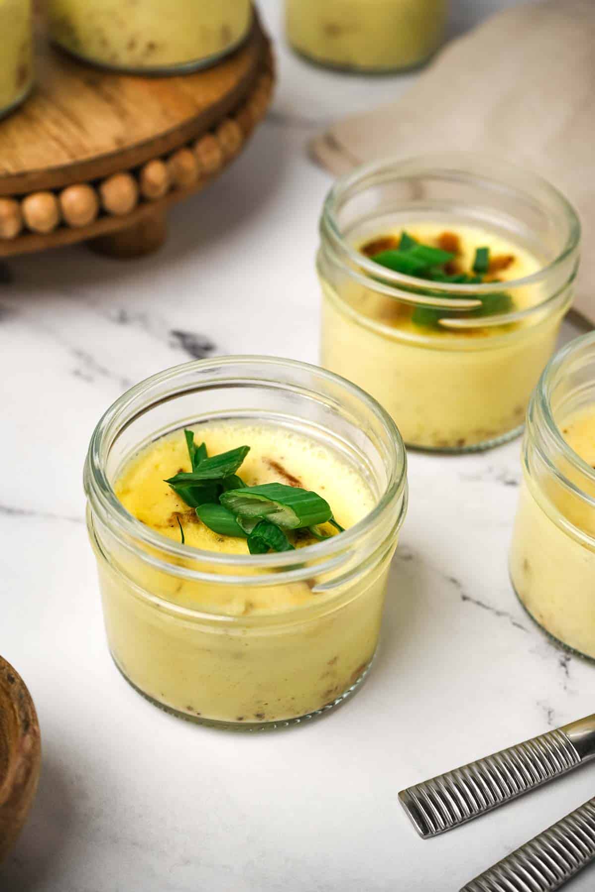 cooked eggs in a glass jar with green garnish