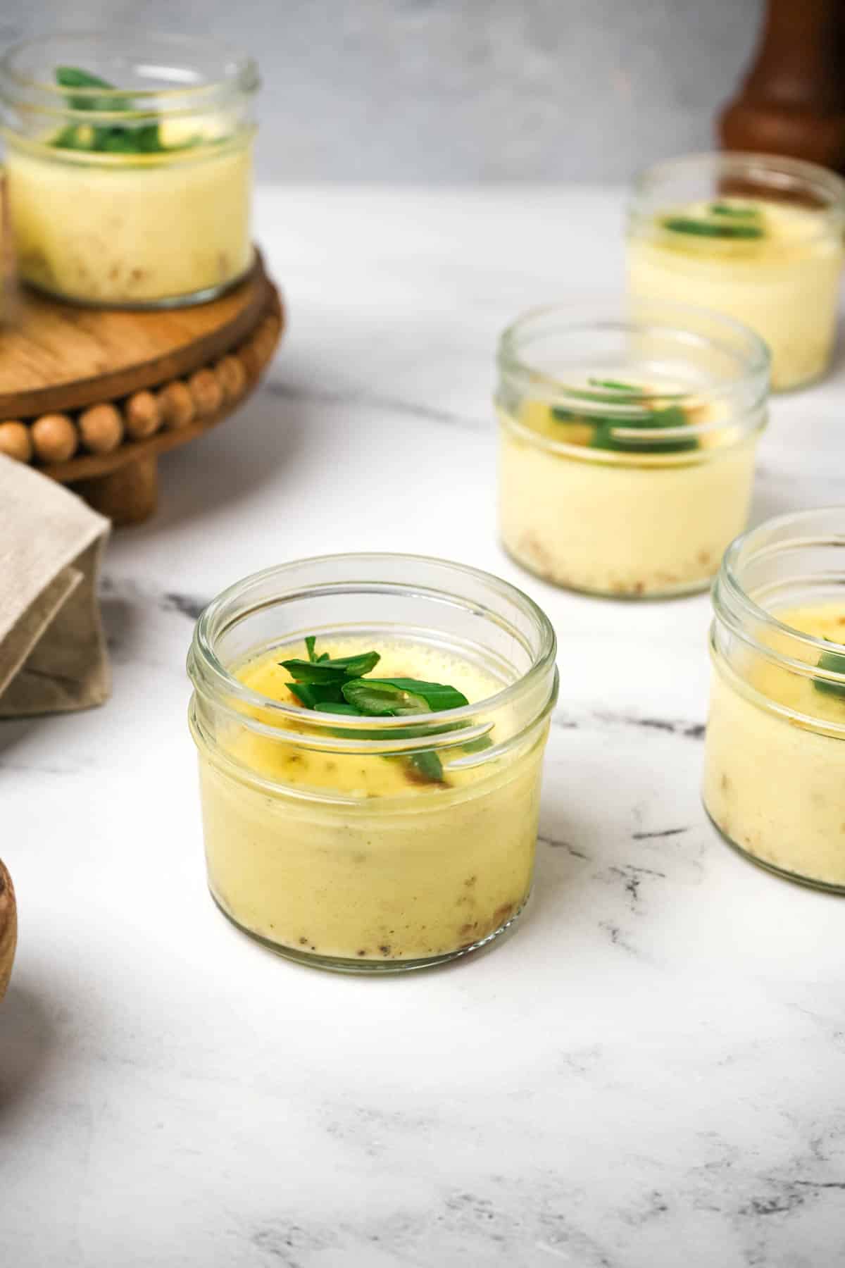 jars filled with yellow cooked egg and green garnishes