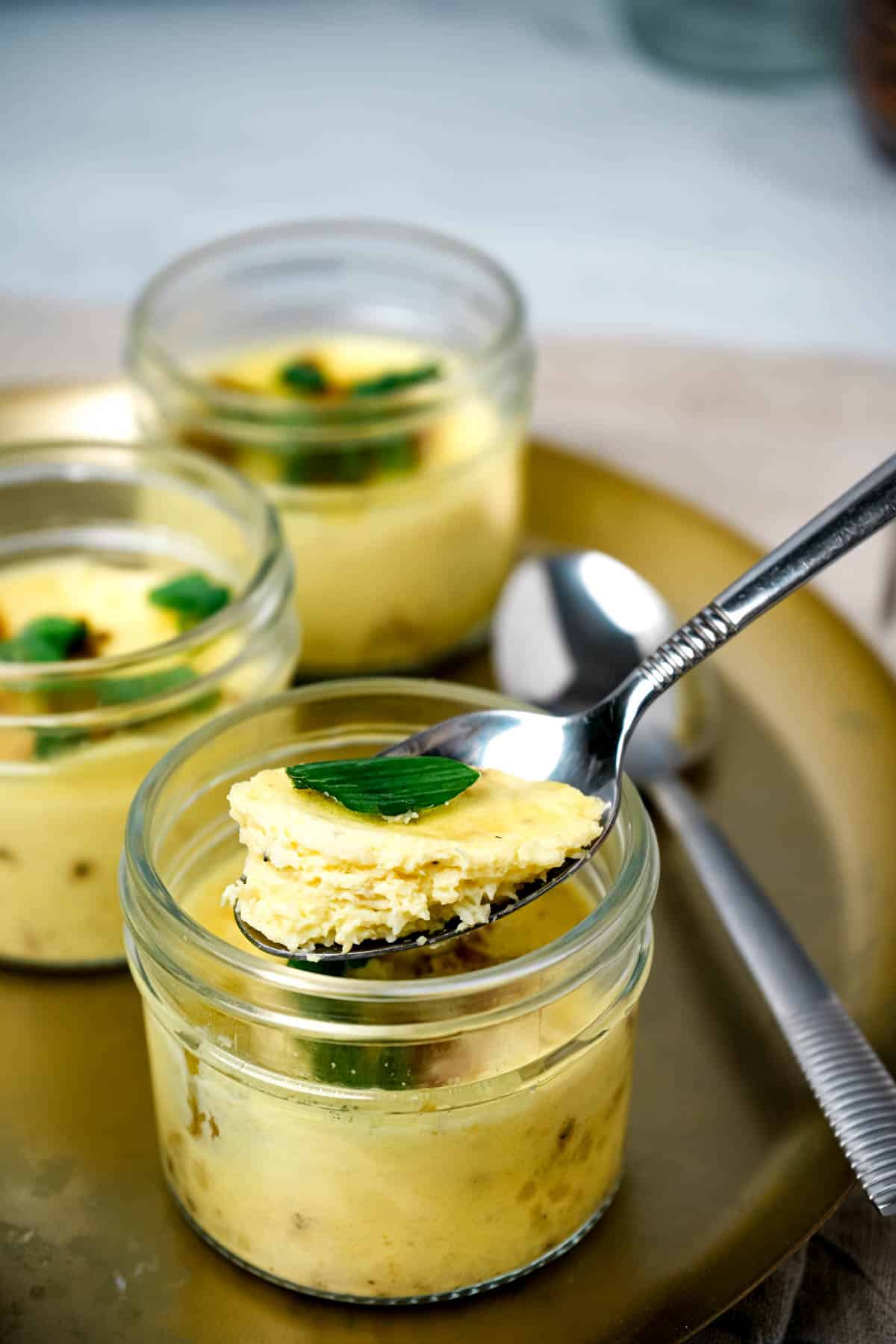 a spoon with a bite of cooked egg over a jar