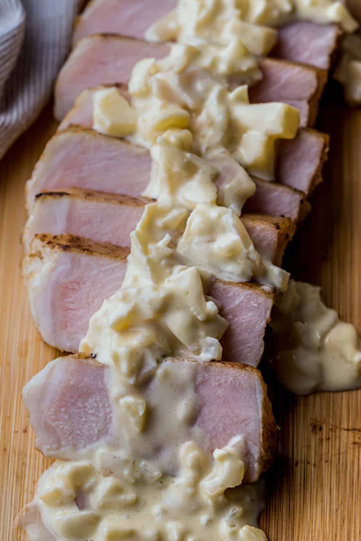 sliced pieces of pork in a chunky white sauce