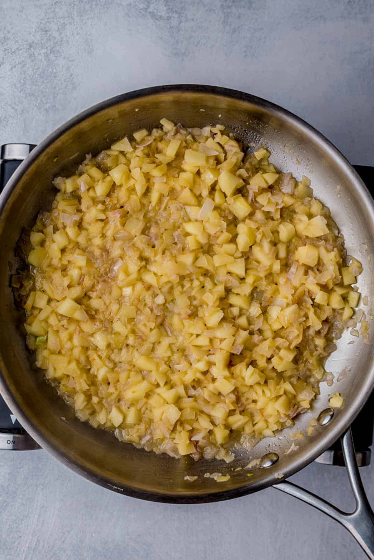 a yellow tinted sauce being cooked in a skillet