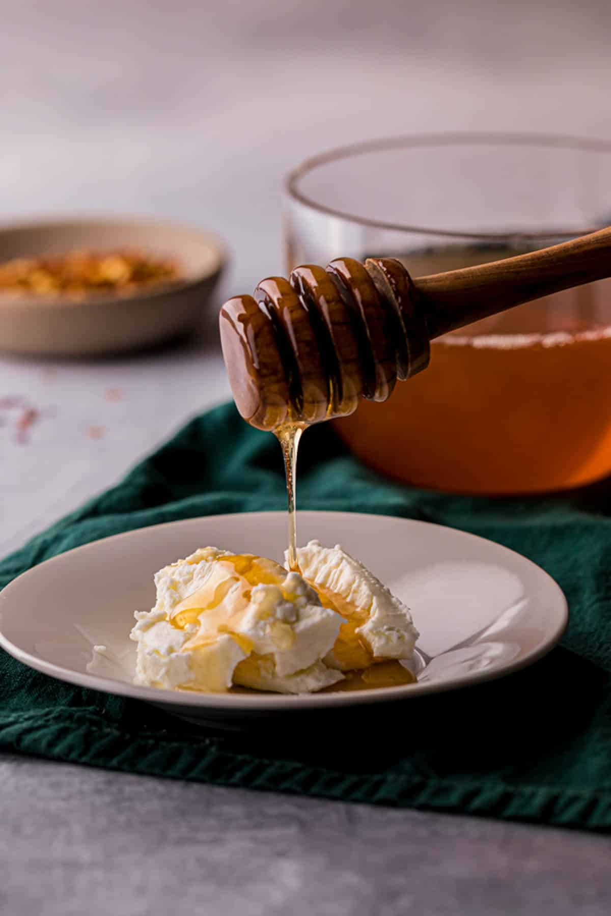honey being drizzled over cheese on a plate