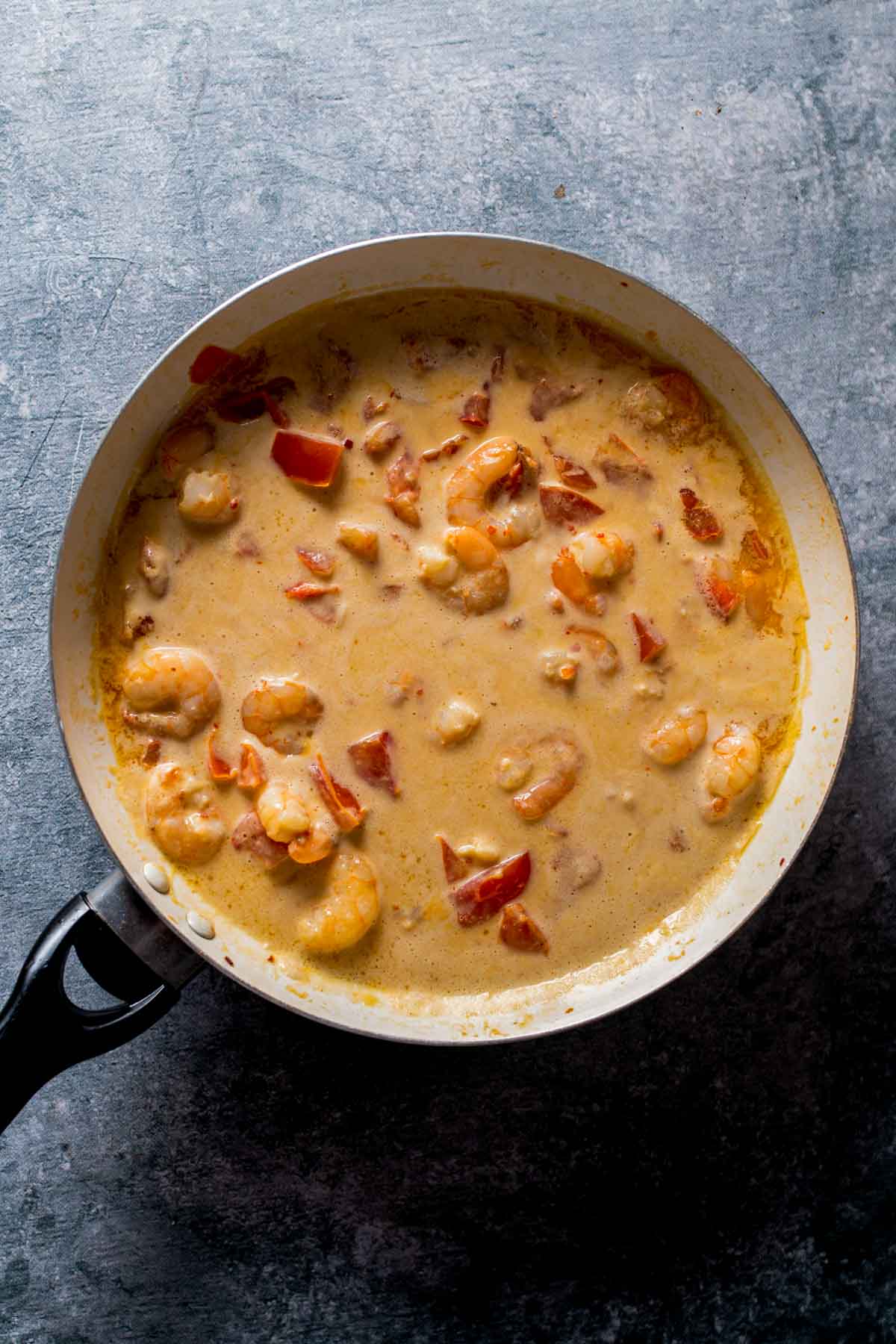 shrimp and tomatoes in a cream sauce in a pan