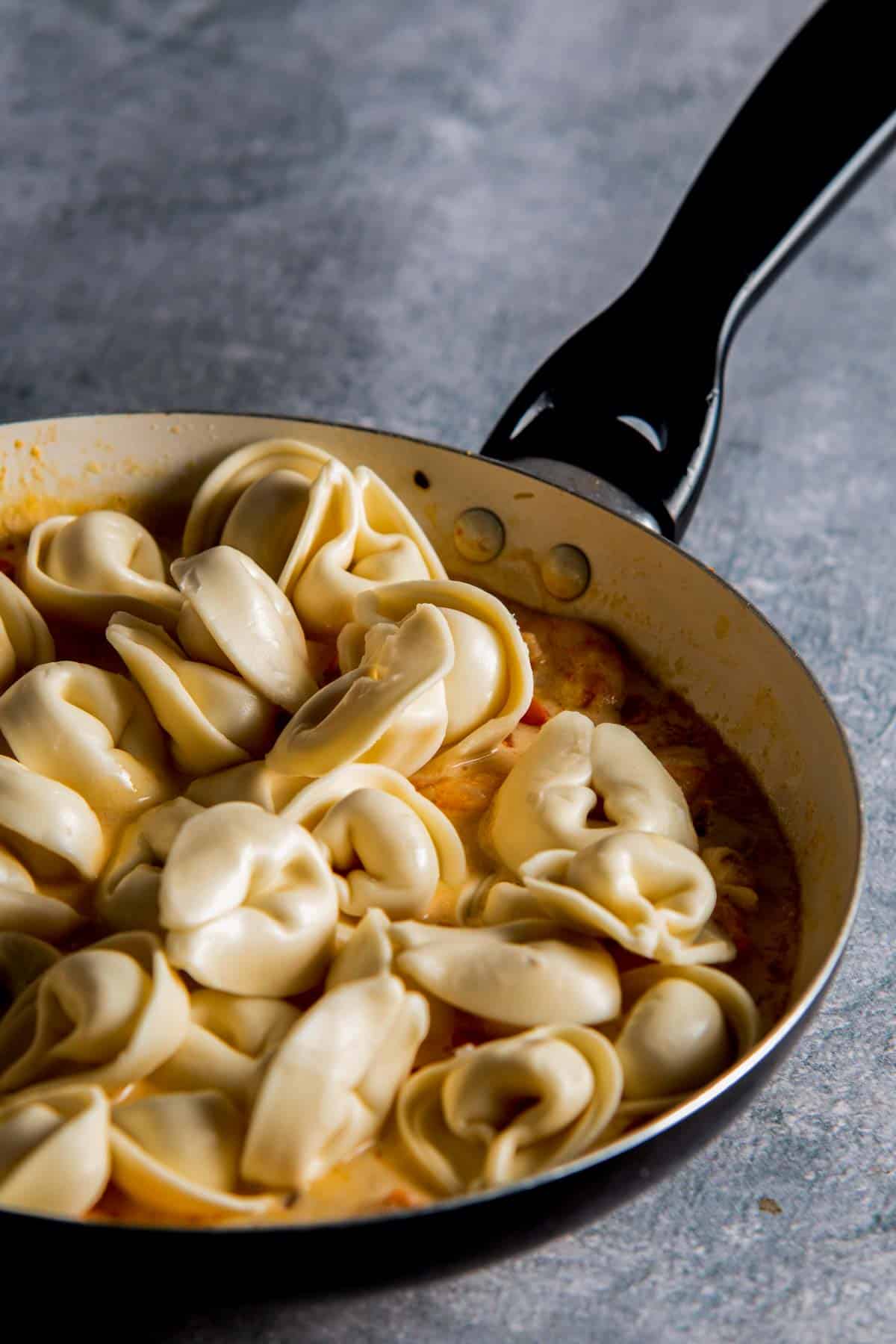 tortellini added to a saute pan