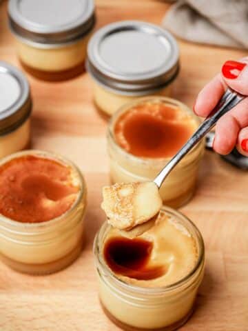 a spoonful of flan over top a jar of flan