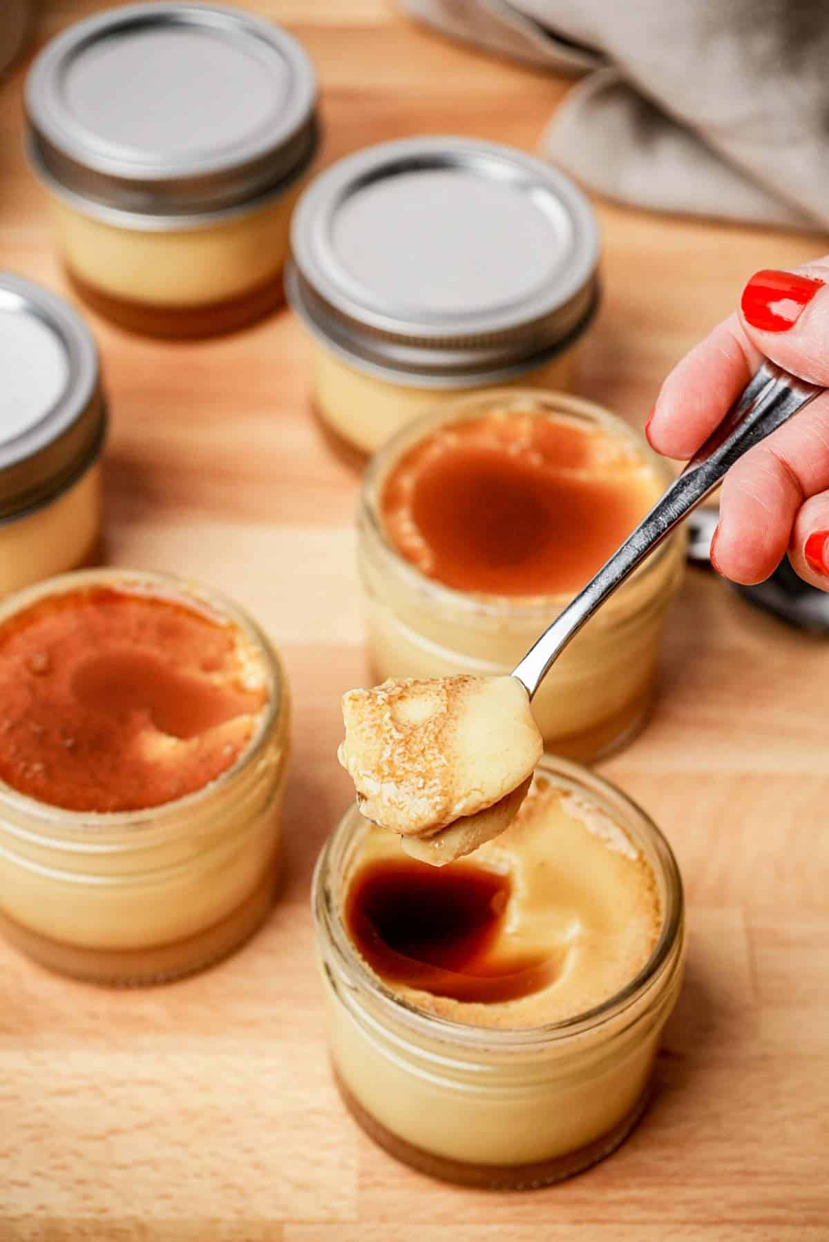 a spoonful of flan over top a jar of flan
