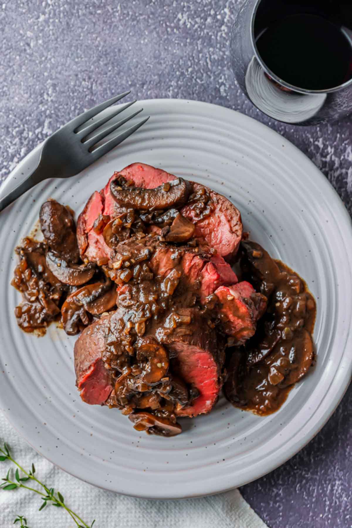 pieces of cooked red meat on a plate with a brown sauce