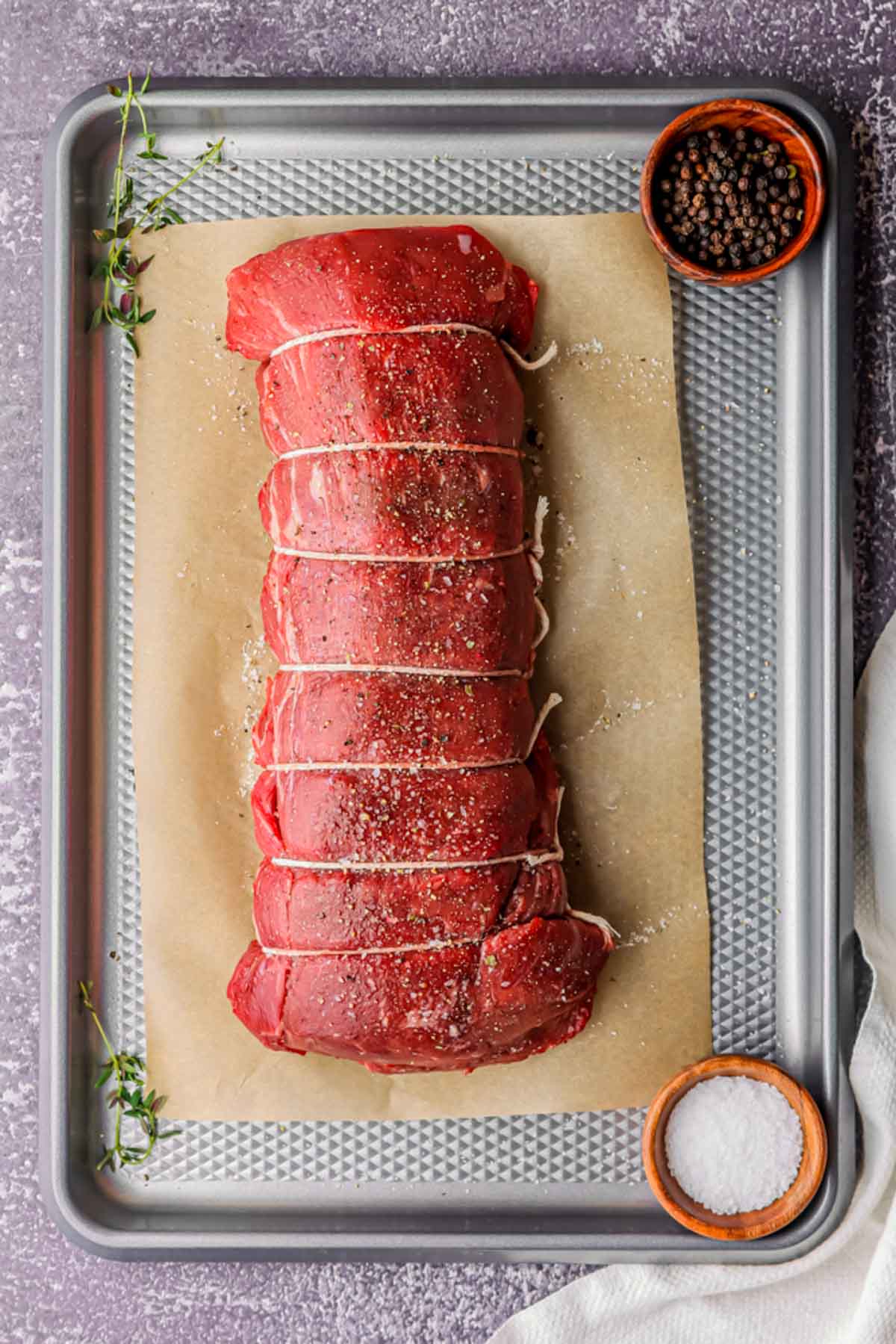 raw beef tenderloin on a baking sheet