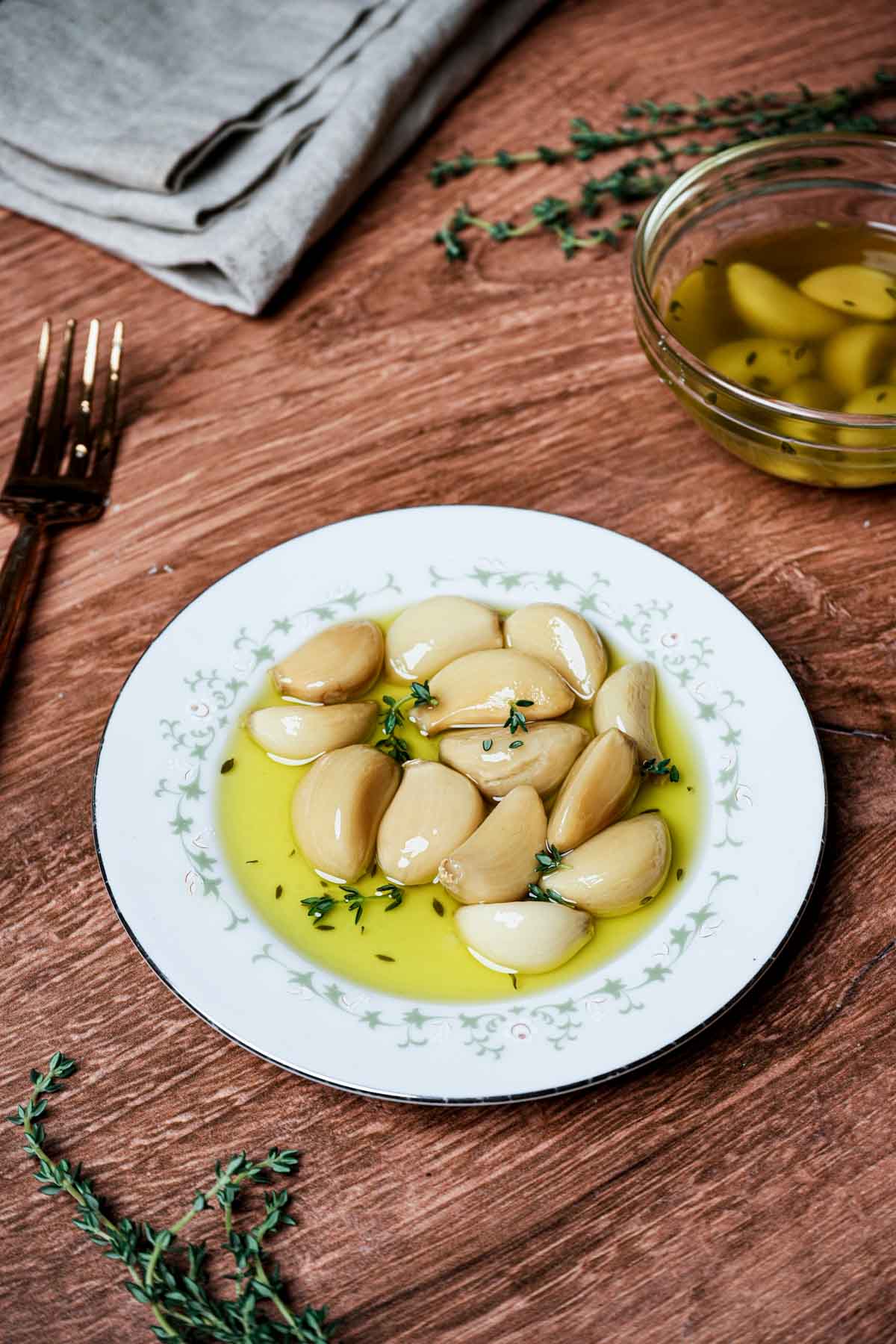 cloves og garlic in oil on a white plate