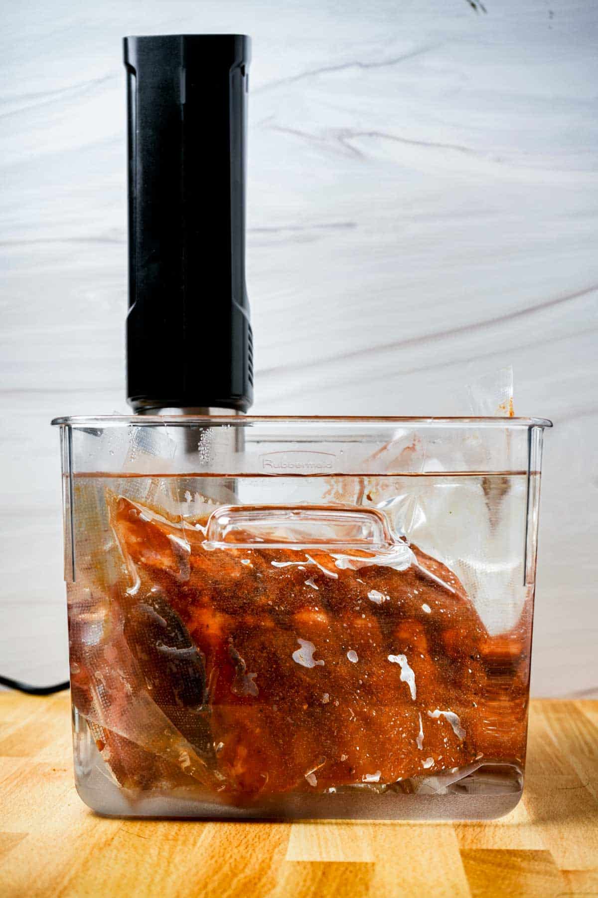 a bag of ribs being cooked in a sous vide water bath