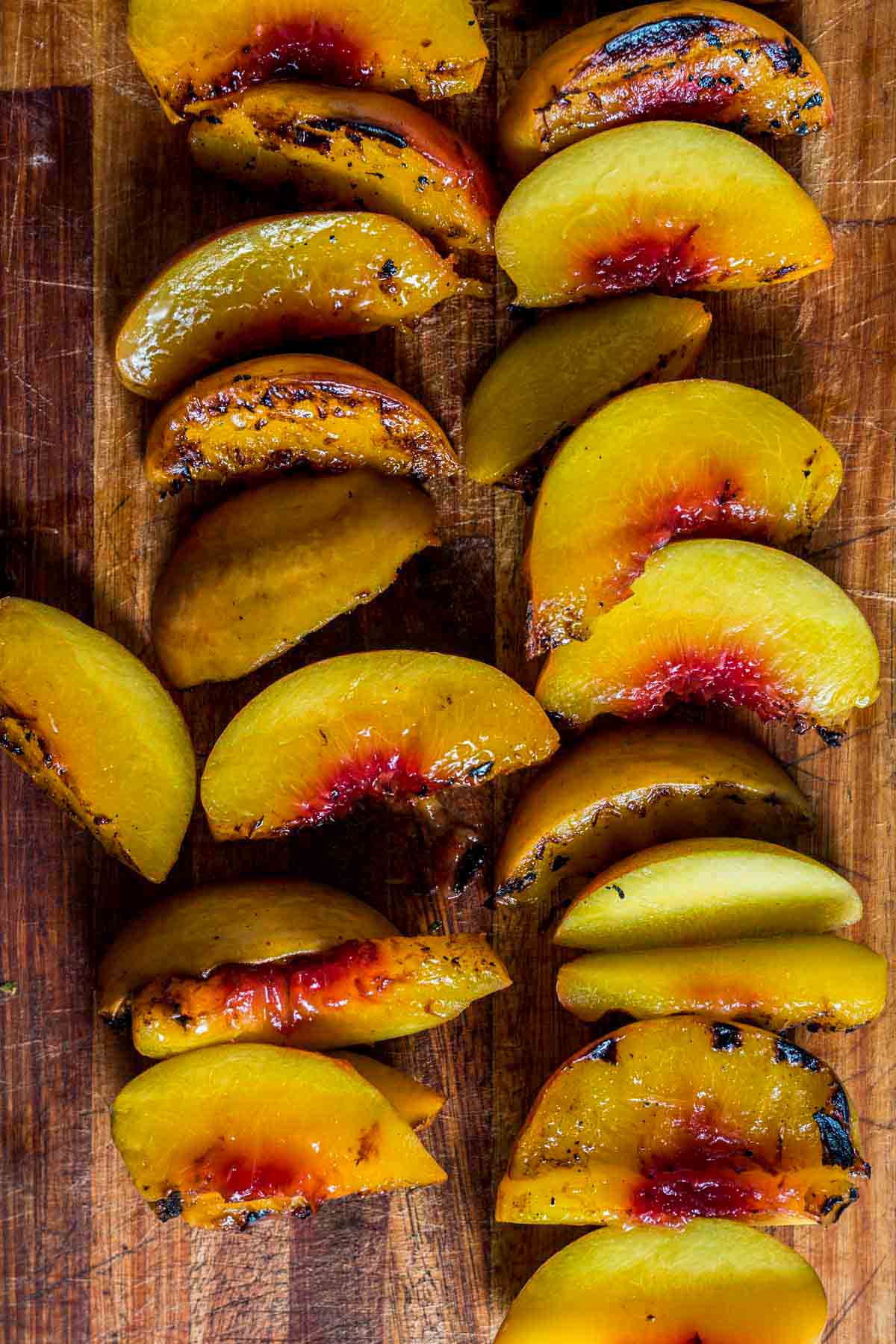 grilled peach slices on a wood board
