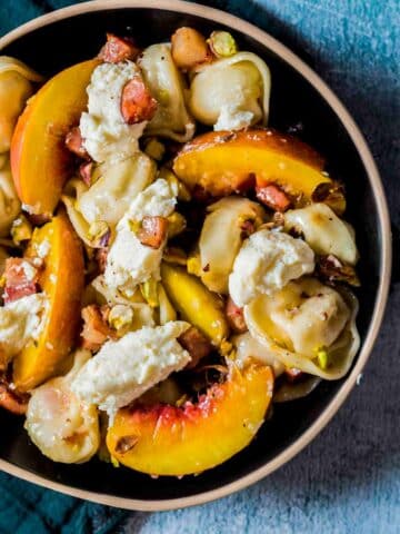 a bowl of peaches, ricotta and cooked tortellini