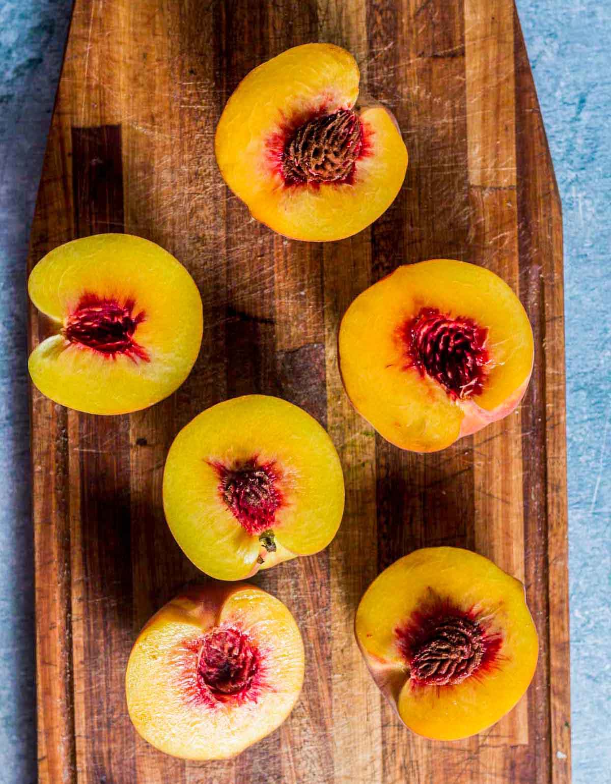 peaches sliced in half on a cutting board