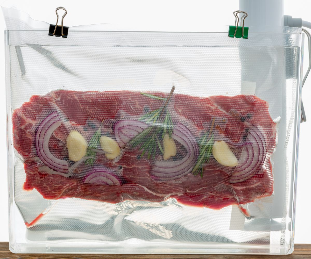 a vacuum sealed piece of meat in a sous vide water bath