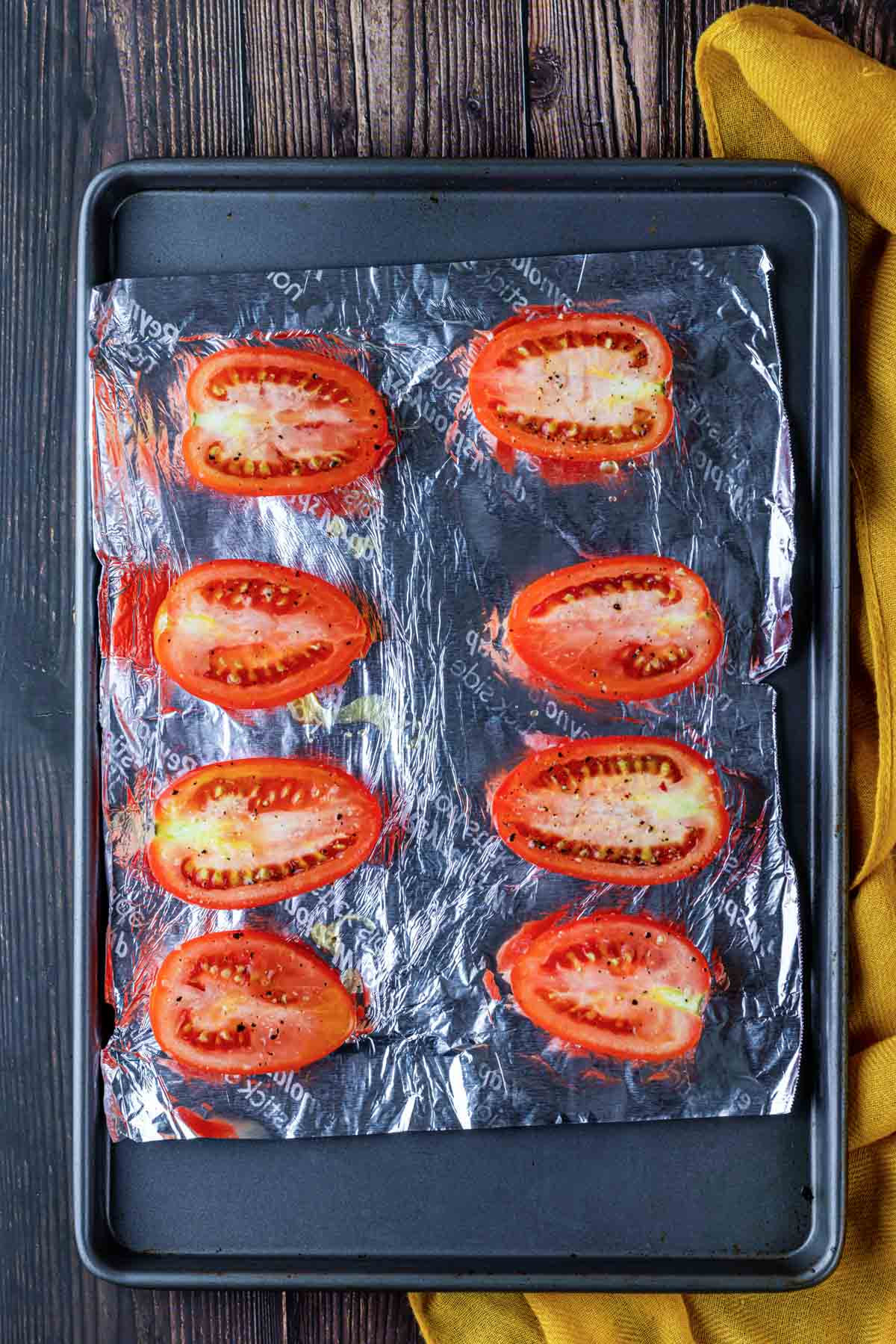 halved tomatoes on a baking sheet