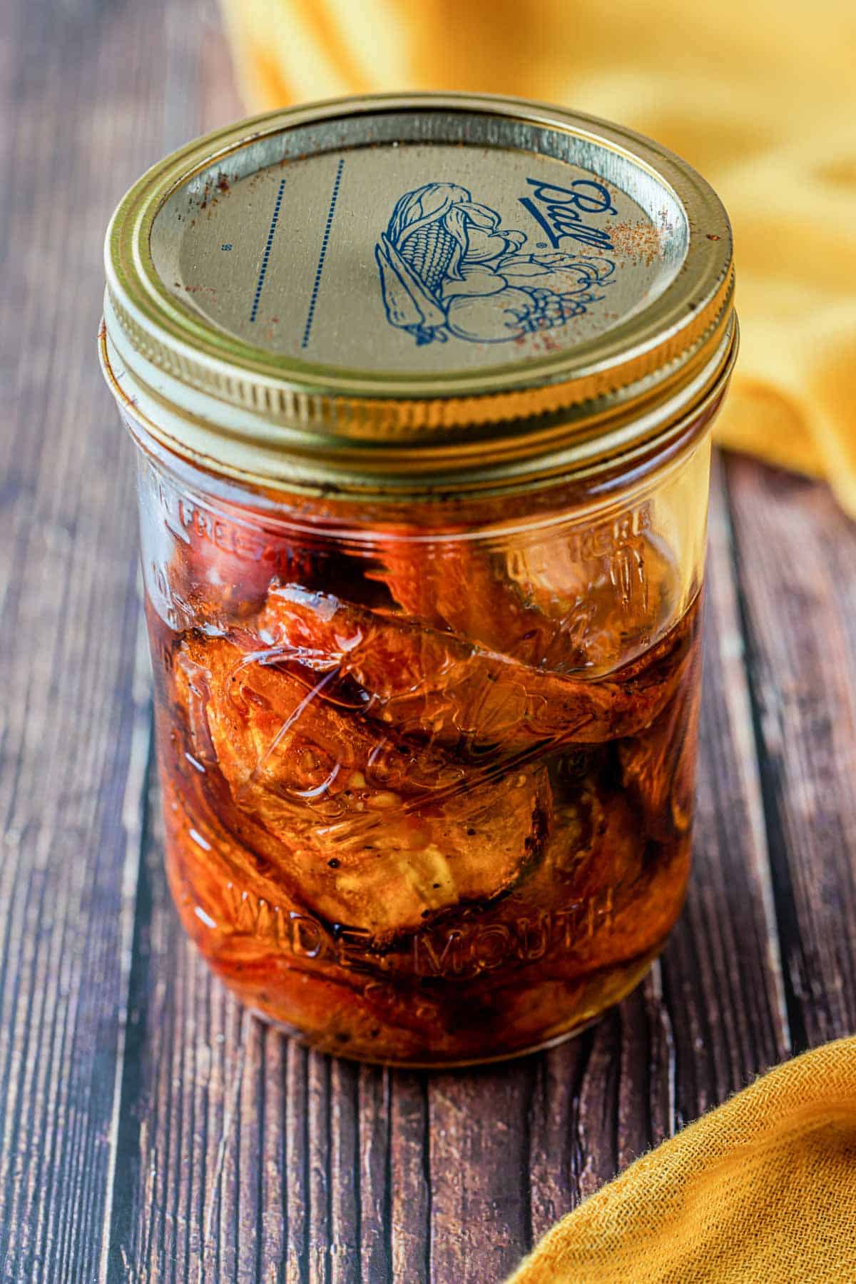 a glass jar of roasted tomatoes in olive oil