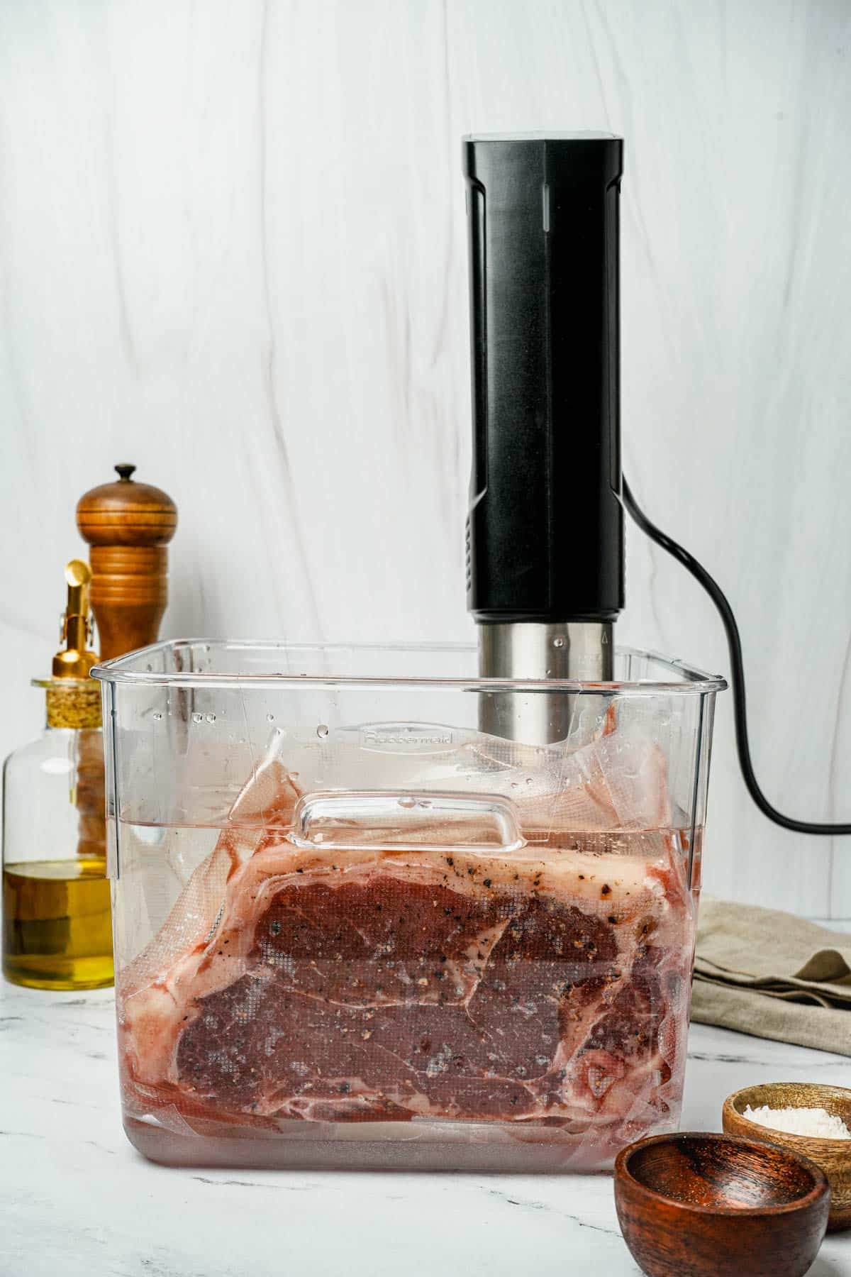 strip steaks in a sous vide container being cooked