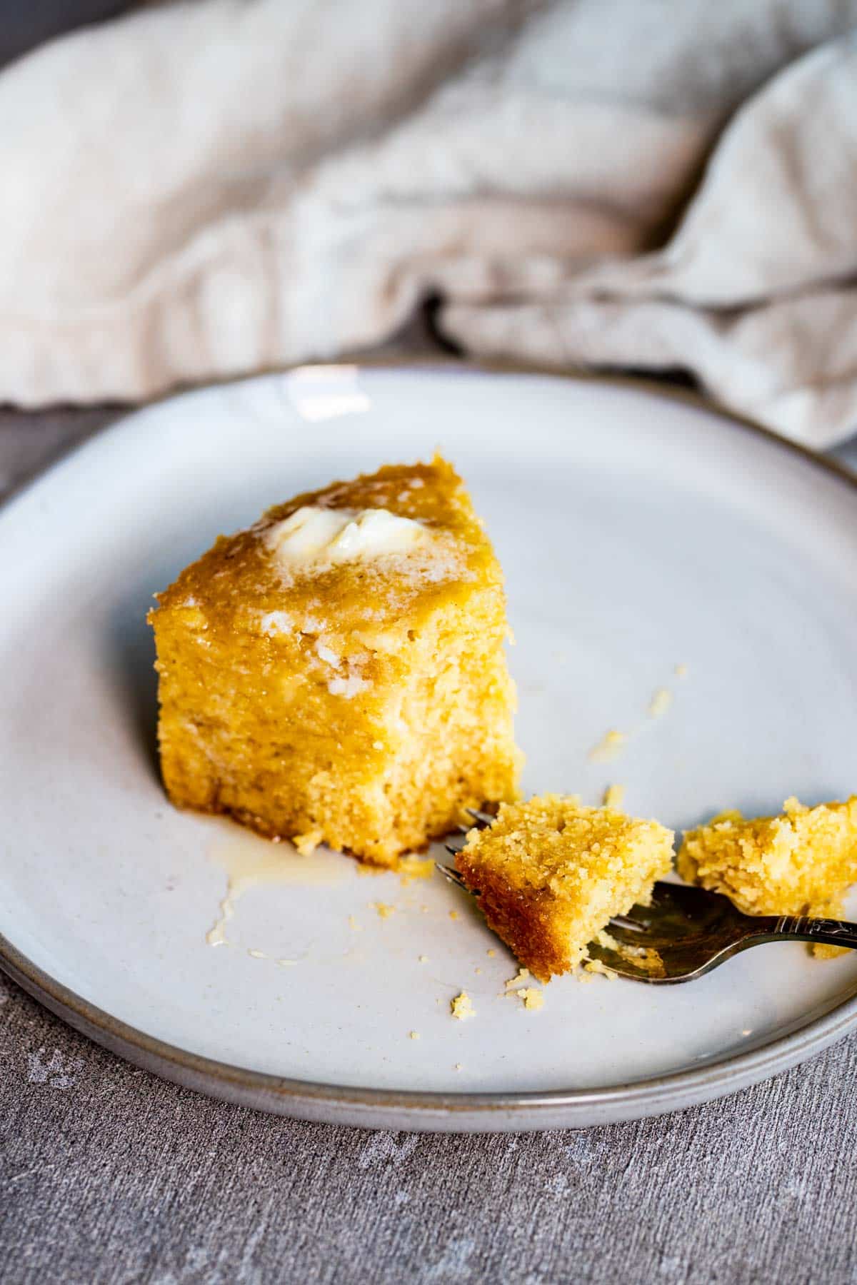 a piece of cornbread on a fork on a white plate