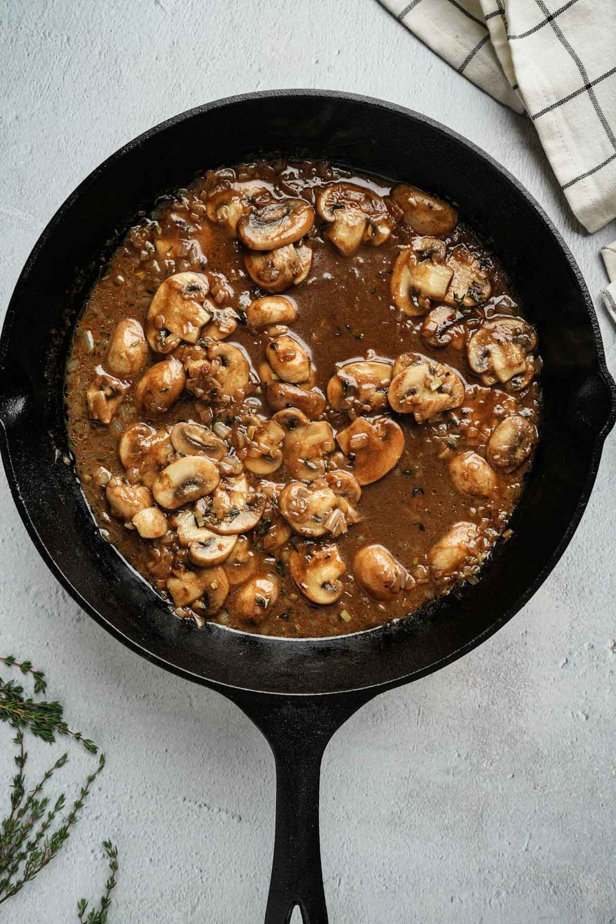 mushrooms in a brown sauce in a skillet