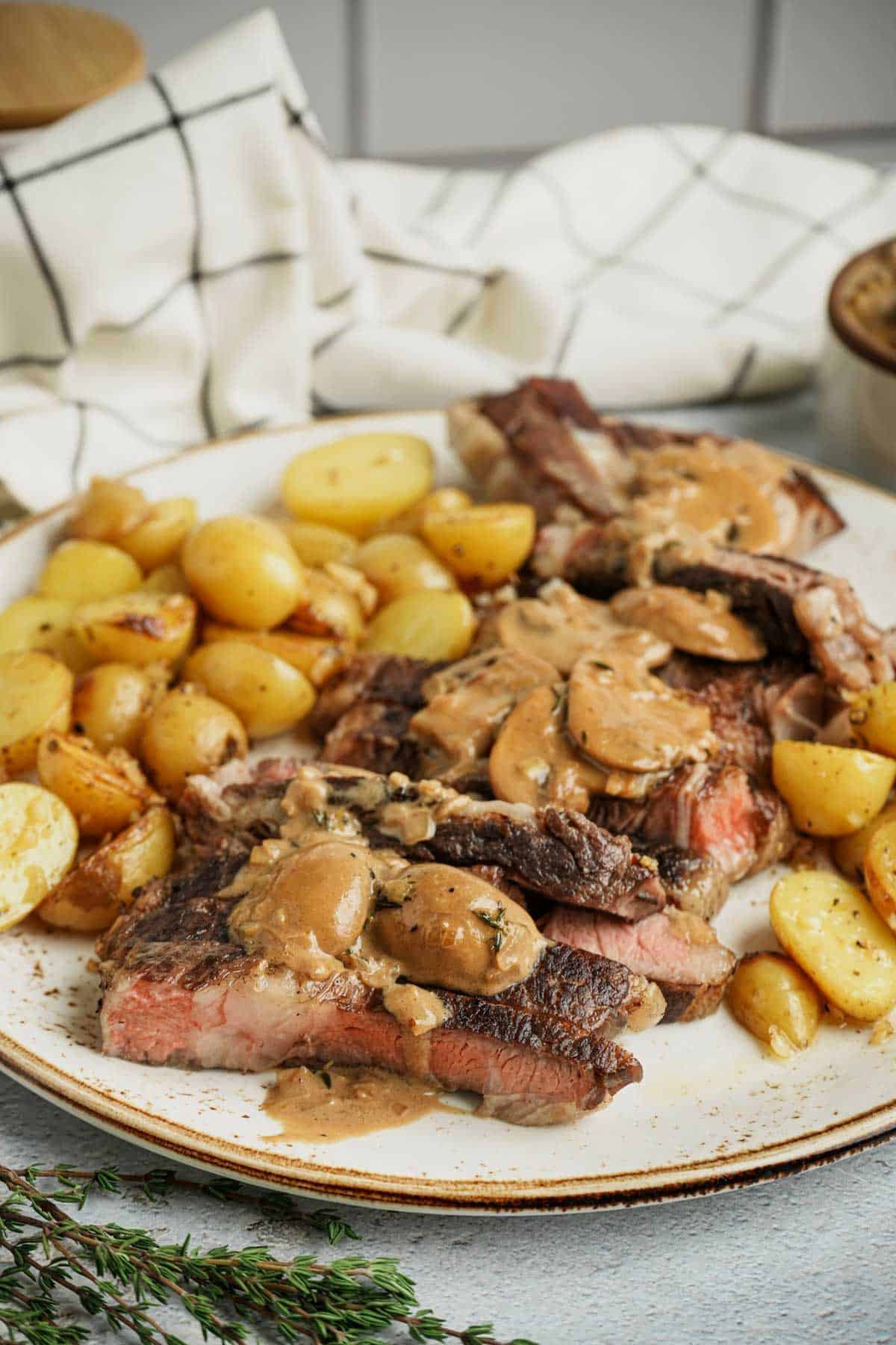sliced steak on a plate with potatoes and gravy