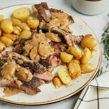 a plate of steak and potatoes smothered in brown mushroom gravy