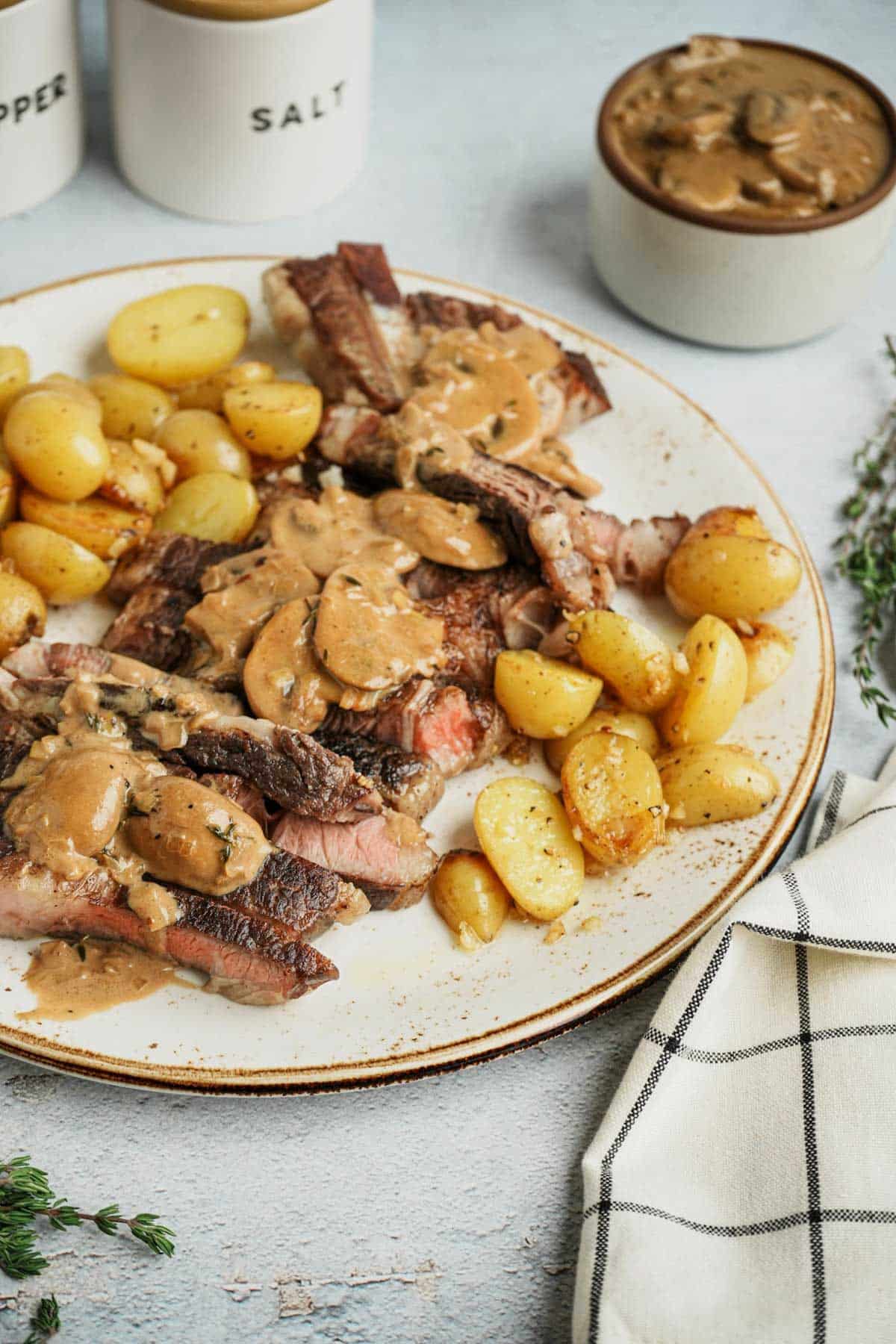 a plate of steak and potatoes smothered in brown mushroom gravy