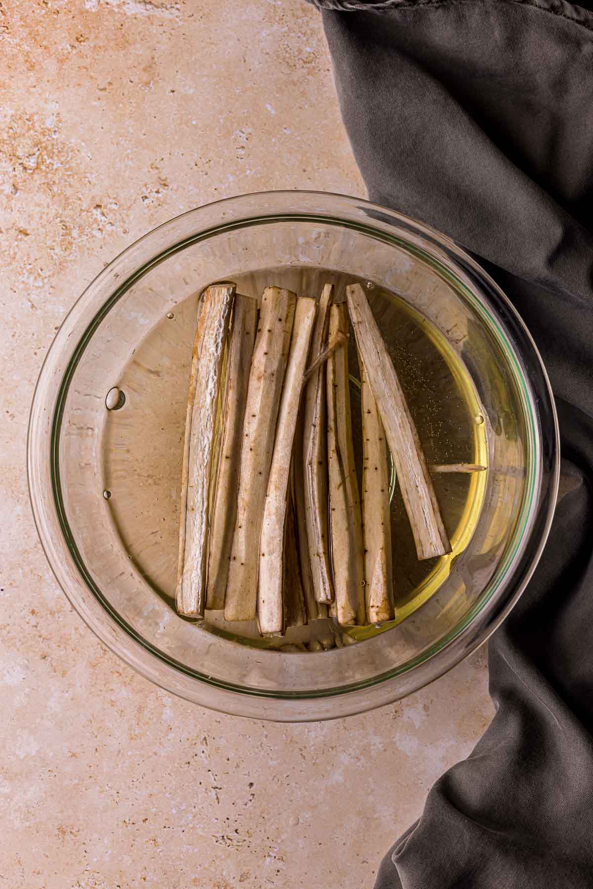 white vegetable sticks in a bowl of clear liquid