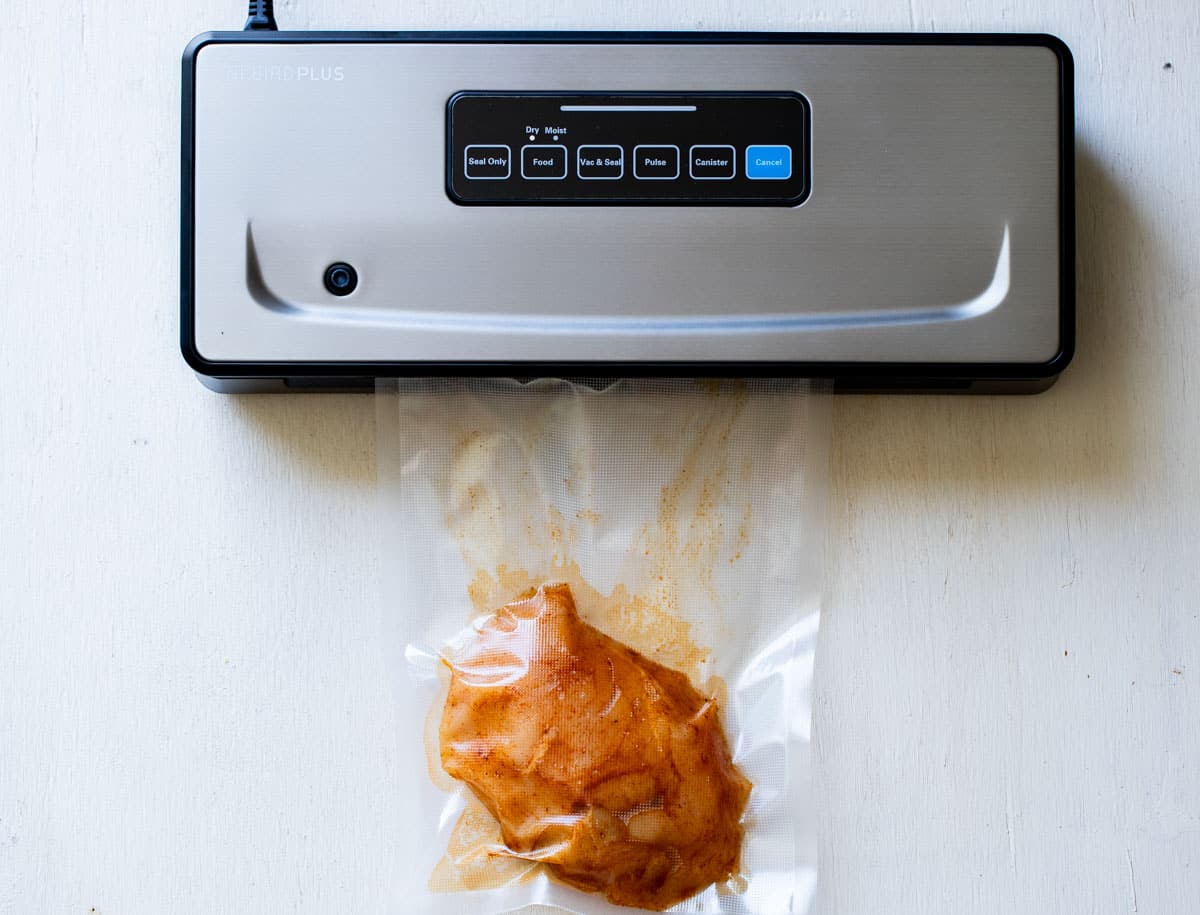 a chicken breast being sealed in a vacuum sealer