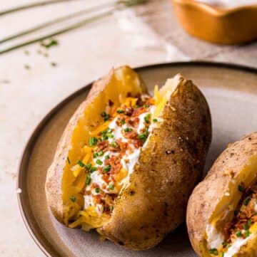 a baked potato stuffed with cheese, chives and bacon