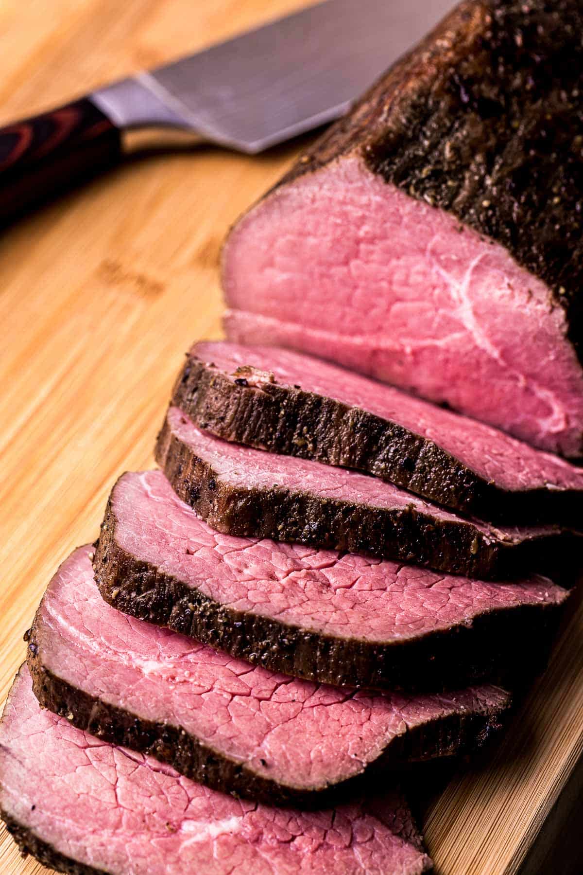 a beef roast sliced on a cutting board