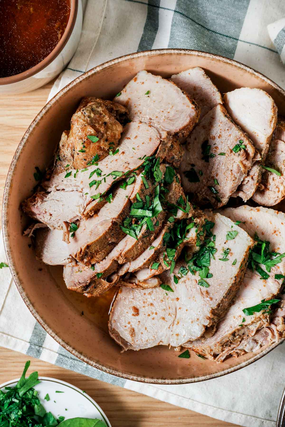 sliced pork in a bowl garnished with green onion