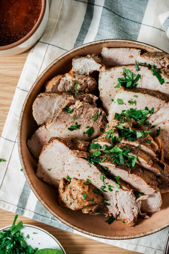 a bowl of pork butt seasoned with green herbs