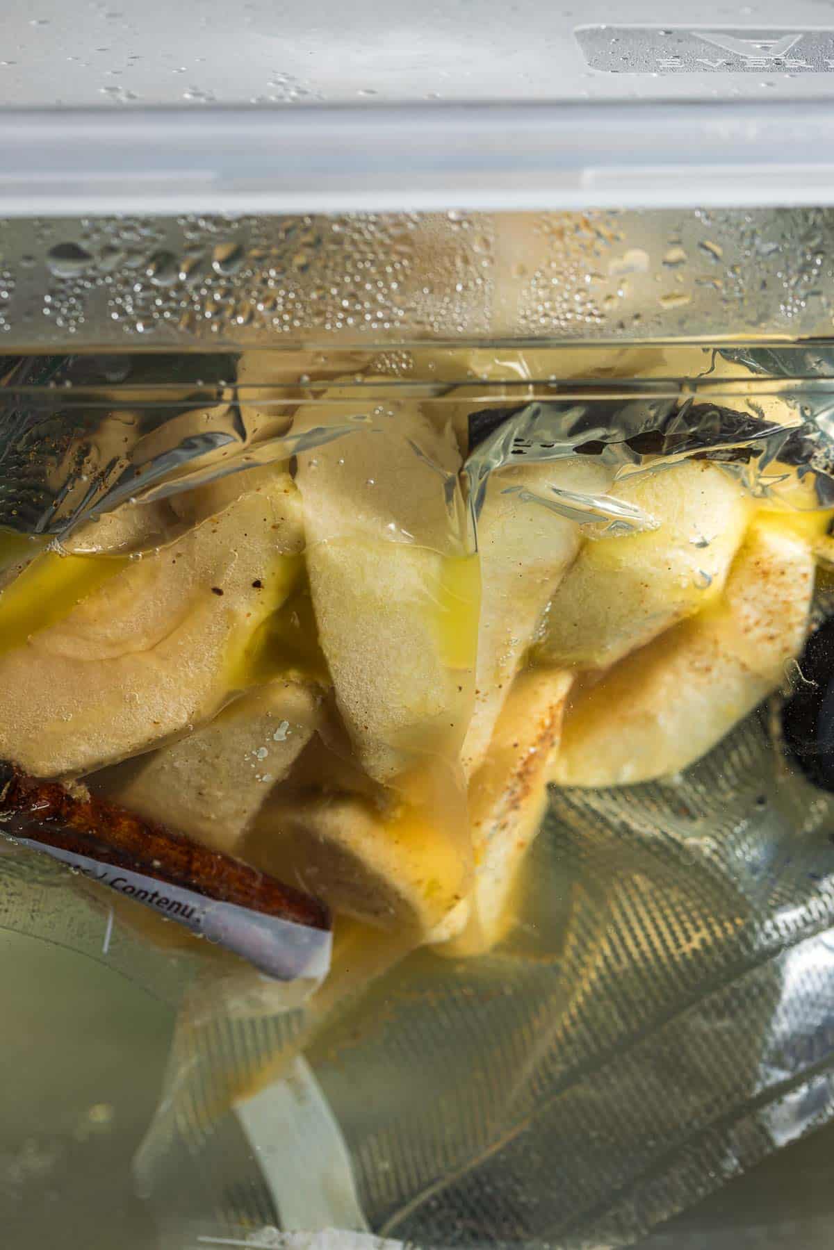 sliced apples in a bag cooking in a water bath