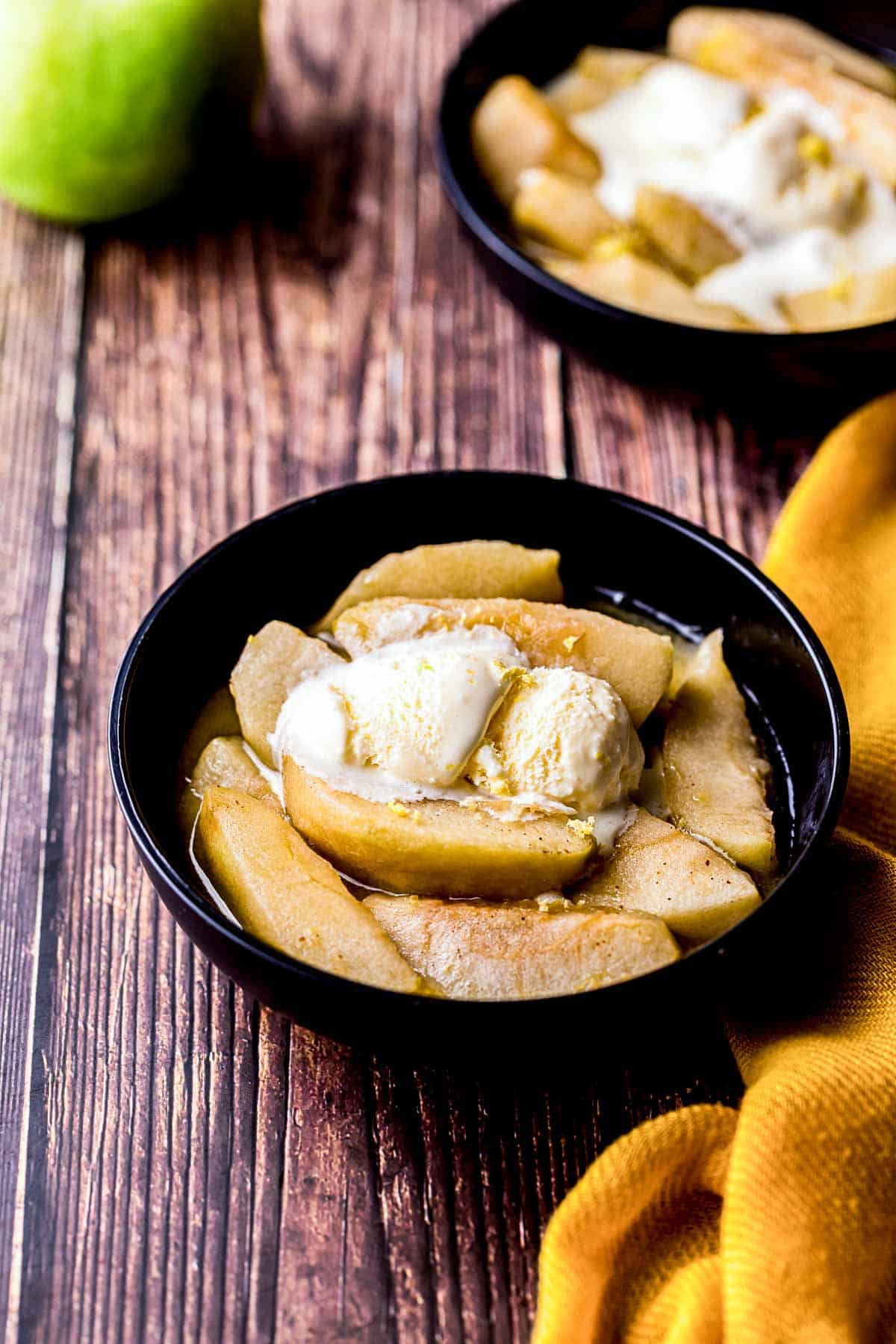 a bowl of cooked sliced apples with ice cream on top