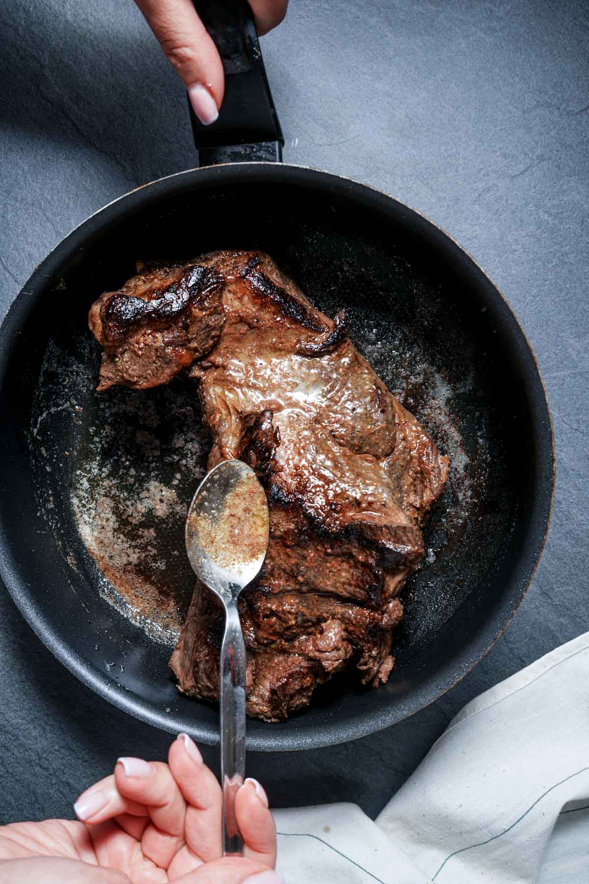 beef being basted with butter in a skillet