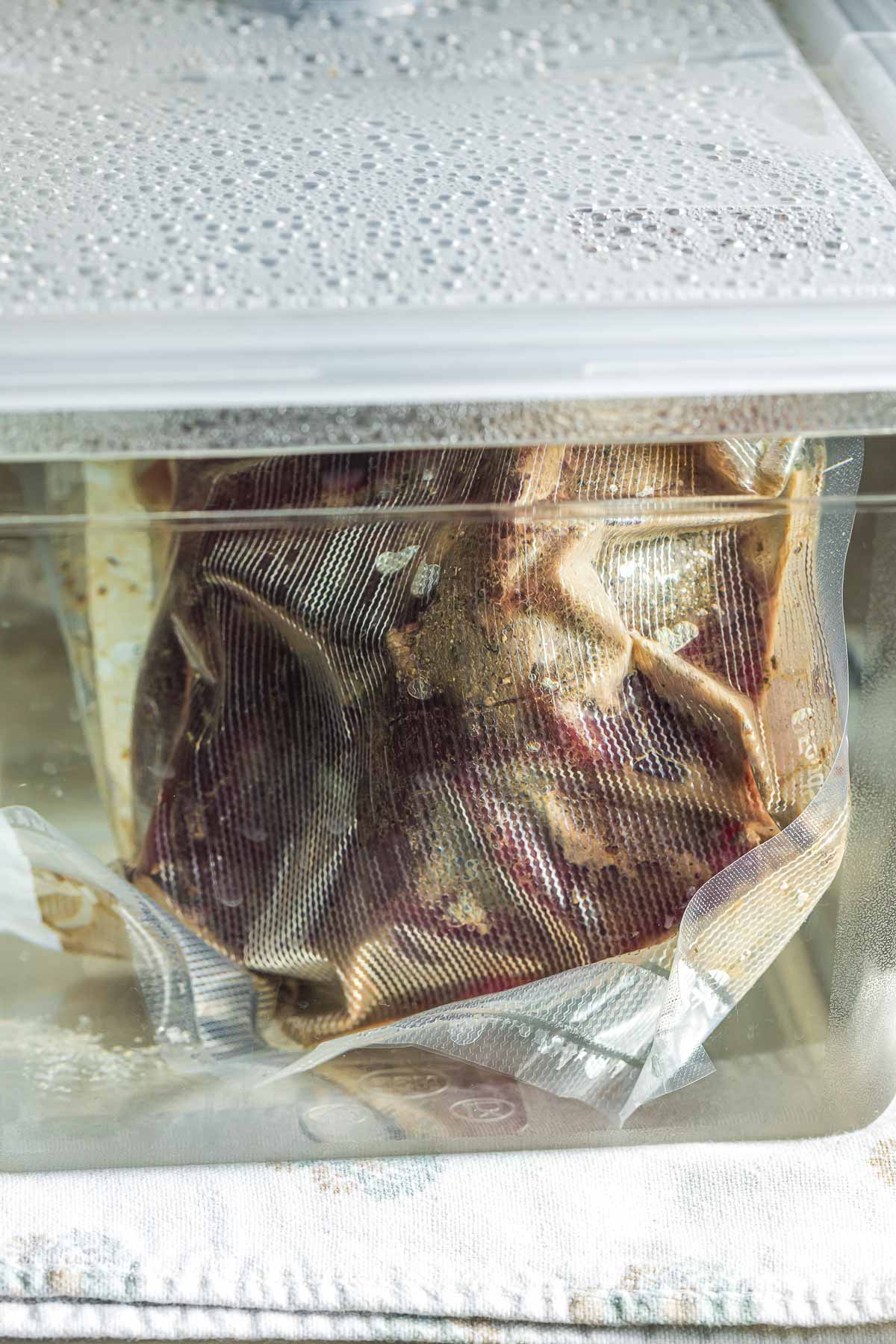 a beef roast in a bag cooking in a water bath