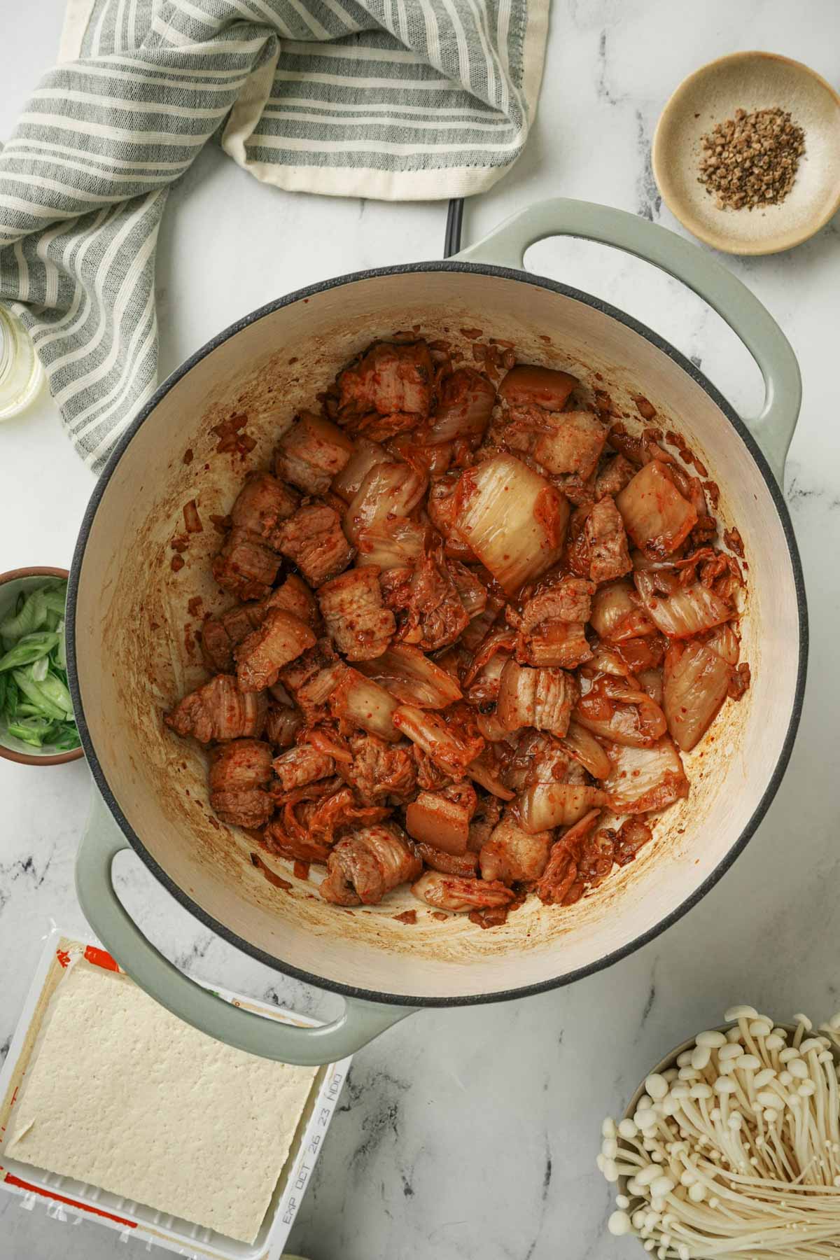 pork and kimchi being coked in a pot