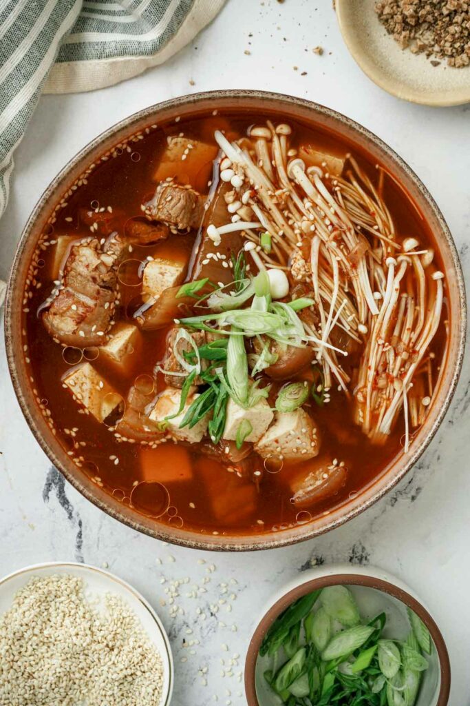 a bowl of soup with green onions and tofu