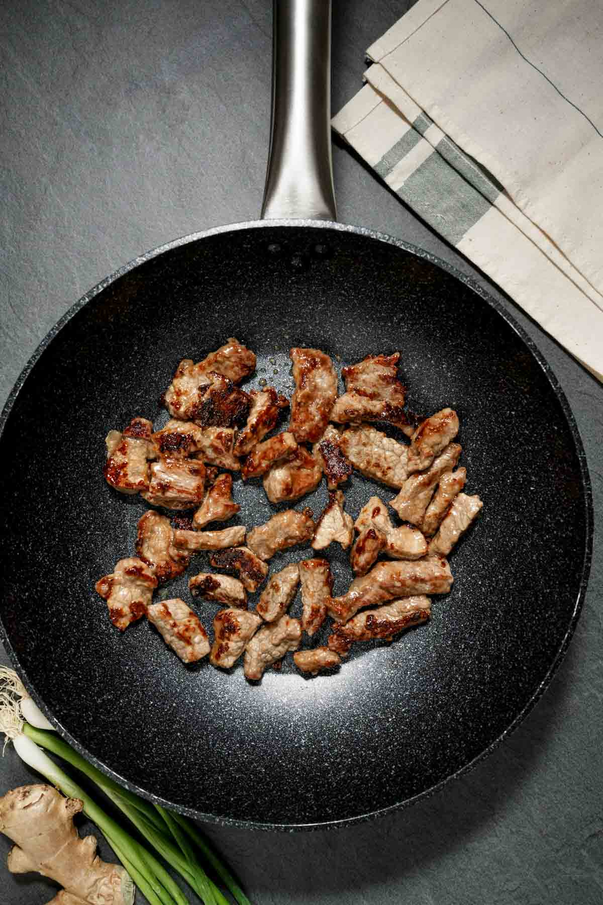 slices of lamb cooking in a skillet