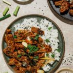 mongolian lamb over white rice on a grey plate