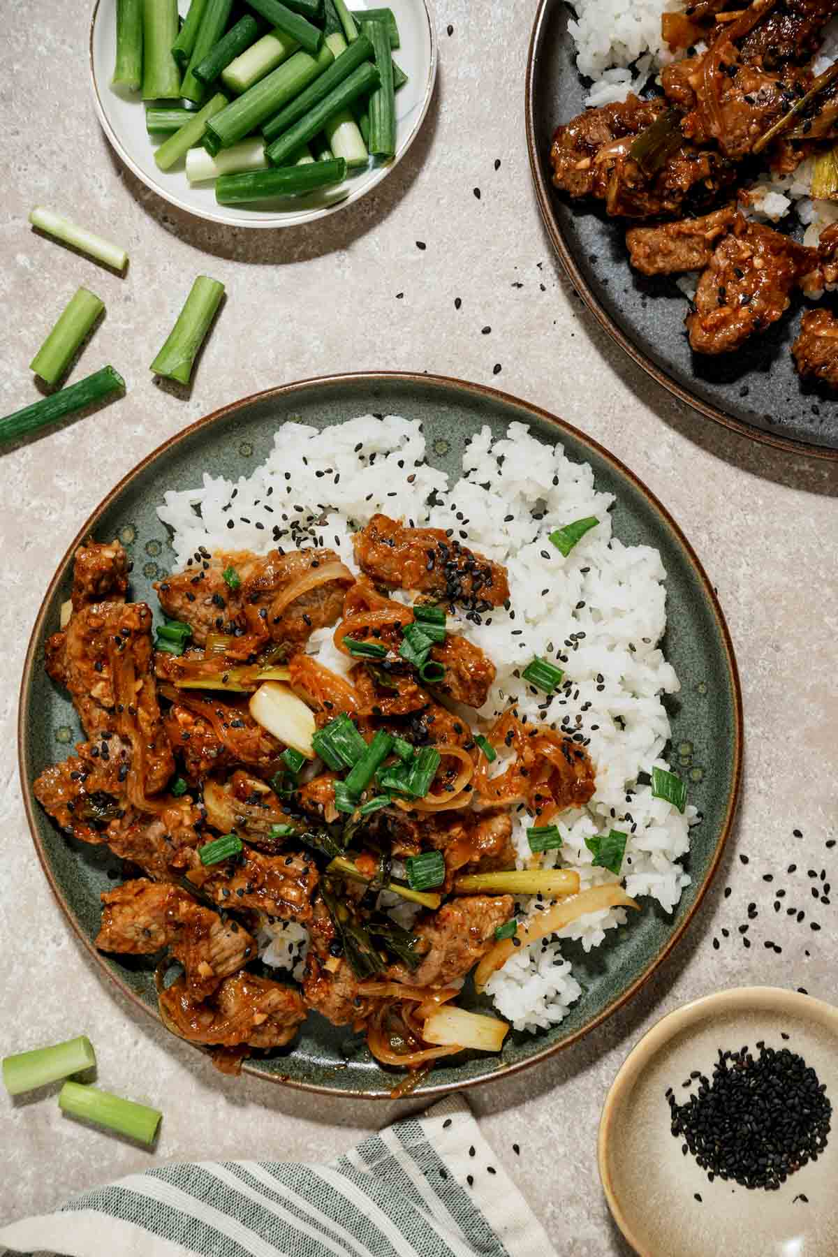 mongolian lamb over white rice on a grey plate