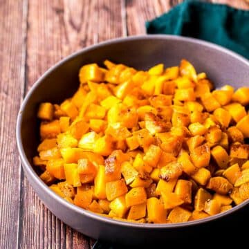 a bowl of cooked butternut squash on a blue towel